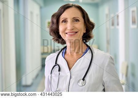Portrait Of Smiling Older Senior Female Professional Doctor Physician Pediatrician Wearing White Rob
