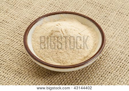 piccola ciotola di ceramica di polvere di frutto di baobab africano contro la tela tela