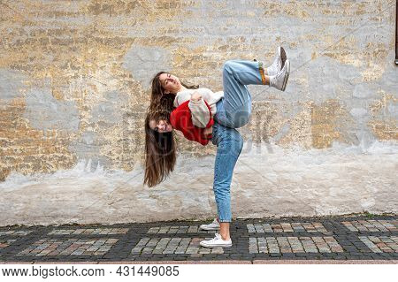 Funny Teenager Carrying Her Best Friend Piggyback On The Pavement At The Old Wall, Positive Emotions