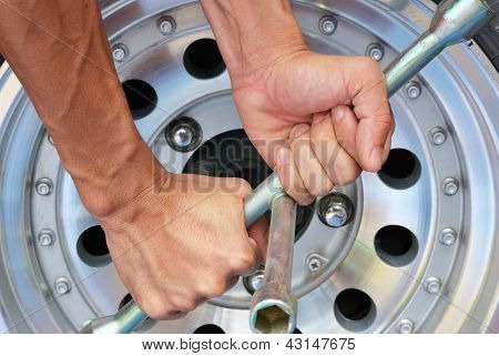 La mano forte tenta di rimuovere il dado della ruota