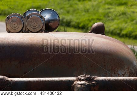 Close-up Of The Boundary Light And Horn Of An Old Rusty Scraper Wagon Fresh Green Grass Background