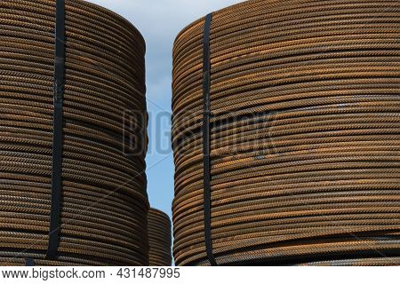 Several Bunches Of Rolled Rusty Structural Steel Against A Blue Sky