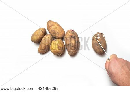 There Are Potatoes On A White Table.next To Rotten Potatoes Separately.