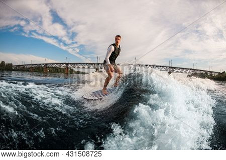 Armless Man Ride The Wave On Wakeboard Against The Background Of Cloudy Sky.