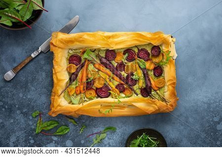 Carrot and Beet Tart with pesto and phyllo dough. Savoury vegetable baking. Homemade vegetarian food.Top view.