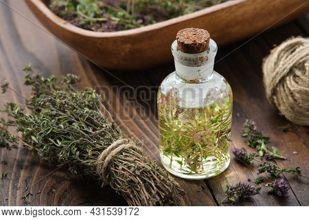 Bottle Of Thyme Essential Oil Or Infusion, Bunch Of Dried Thymus Serpyllum Plants And Wooden Crate F