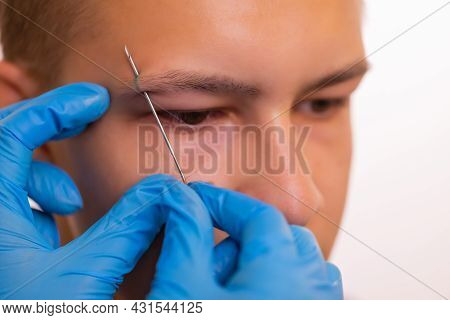 Man With Pierced Eyebrow. Three Small Black Piercings.