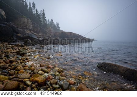 Multi-colored Round Rocks On Little Hunters Beach In Acadia National Park, Maine. Tide Coming In As 