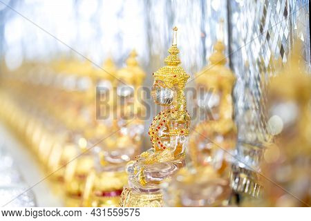 Transparent Crystal Buddha In Gold Suit With Blur Bokeh Shining Background.