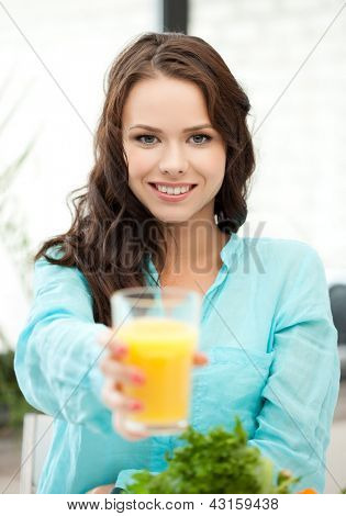 jeune femme tenant le verre de jus d'orange