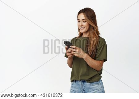 Image Of Smiling Adult Woman Chatting In App, Holding Smartphone, Looking At Mobile Phone Screen Hap