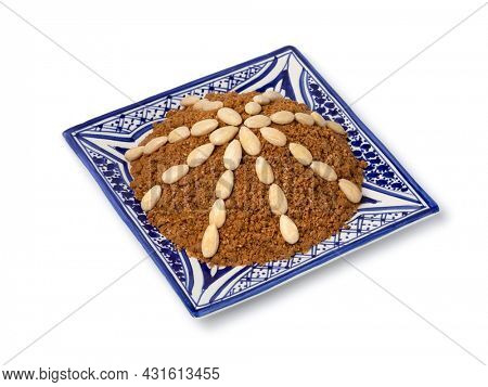 Dish with traditional Moroccan homemade sellou decorated with roasted almonds close up isolated on white background