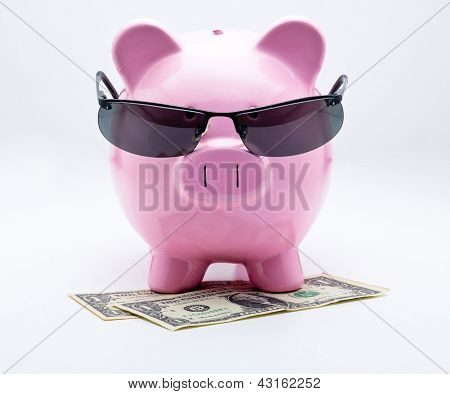 Piggy bank with sunglasses on U.S. dollars