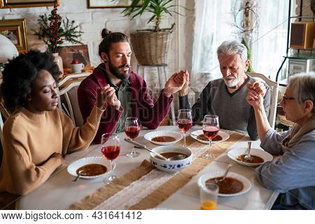Family And Religious Concept. Group Of Multiethnic People With Food Praying Before Meal