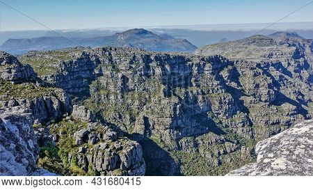 The Landscape Of The Top Of Table Mountain In Cape Town. There Is Scant Green Vegetation On The Gray