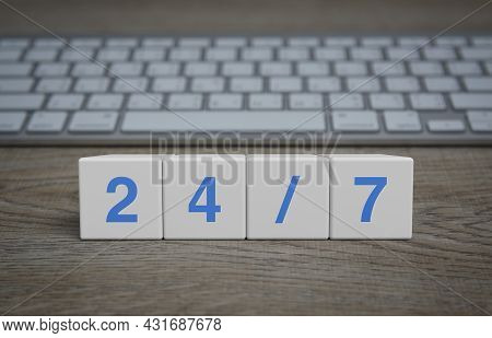 247 Letter On White Block Cubes On Wooden Table With Modern Computer Keyboard, Business Full Time Se