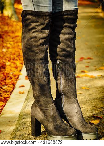 Woman Wearing Long Black Heeled Knee High Boots And Jeans. Autumn Fashion, Warm Footwear Boots.