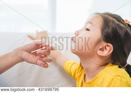 Adorable Asian Girl Kid Getting Swab Test At Home By Her Parent. Rapid Self Test For Covid-19, Antig