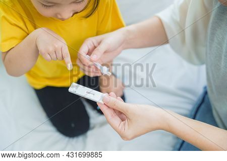 Adorable Asian Girl Kid Pay Attention With Swab Test Process By Her Parent. Rapid Self Test For Covi