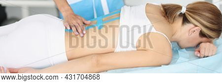 Doctor With Xray Putting Her Hand On Back Of Patient With Kinesio Tapes