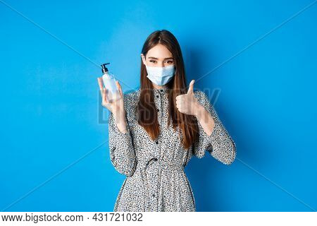 Covid-19, Social Distancing And Healthcare Concept. Beautiful Girl In Medical Mask Using Hand Sanizi