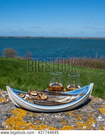 Smoked Sprattus Or Sprats Sea Fish Served Outdoor With View On Blue Sea Water