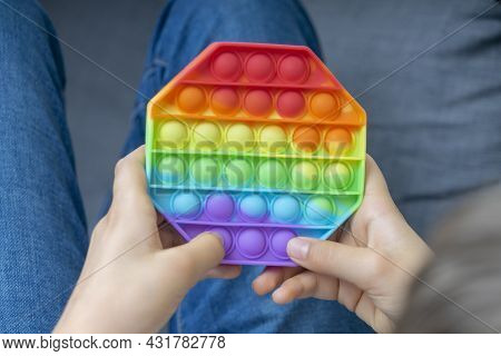 Boy Playing With Sensory Pop It Fidget Toy At Home. Push Pop-it Fidgeting Game Helps Relieve Stress,