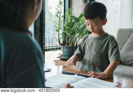 Asian Mother Teaching Child ​boy Learning Math With An Abacus, Education Concept, Home School, Socia