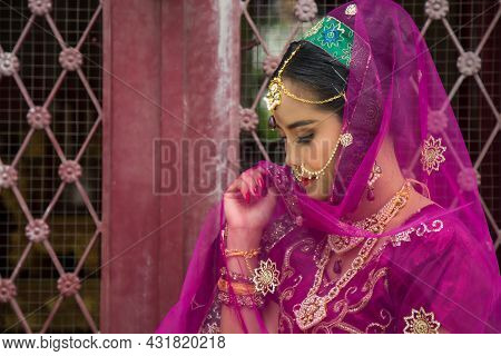 Portrait Asian Woman In A Margenta Indian Tradition Sari, She Is Looking At Down At Side A Wrought I