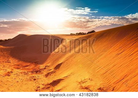 Red sand dune with ripple and blue sky