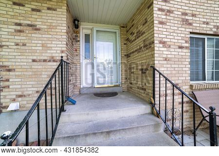 Front Door Of A House With Bricks And Metal Railings