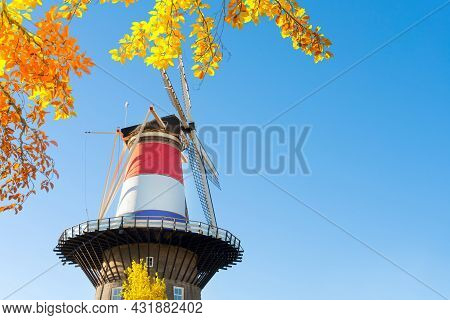 Windmill Of Leiden Wrapped In Netherlands Three Colored Flag, Holland At Fall