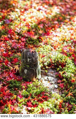 Japanese Jizo Sculpture Doll With Falling Red Maple Leaf In Japanese Garden At Enkoji Temple, Kyoto,