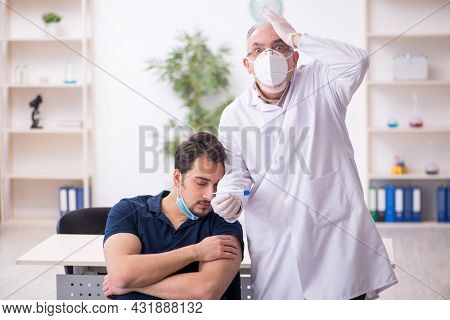 Young male patient visiting old male doctor in vaccination conce