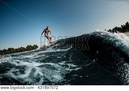 Gorgeous View Of Adult Man Riding On The Wave With Hydrofoil Foilboard On Background Of Blue Sky