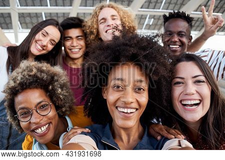 Young African American Girl Takes A Cell Phone Photo With Her Multiracial Group Of Friends. Concept 