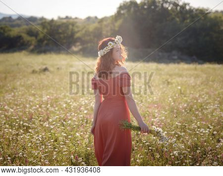 Red-haired Woman On A Field On A Summer Evening