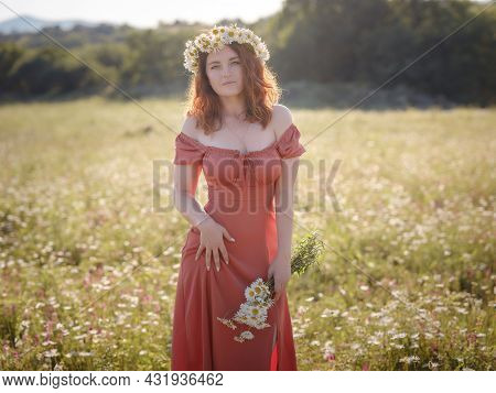 Red-haired Woman On A Field On A Summer Evening