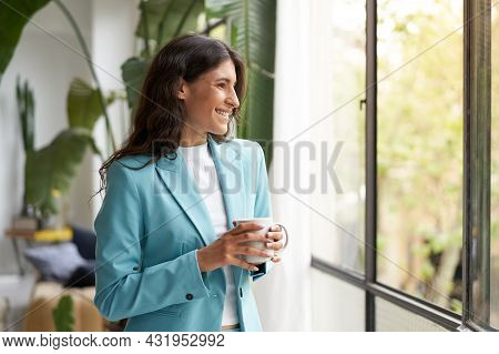 Young Smiling Business Woman Satisfied With A Job Well Done Relaxing With Her Morning Coffee Or Tea,