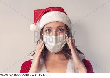 Beautiful Young Woman In Red Santa Claus Costume And Protective Medical Mask Against Virus. Concept 