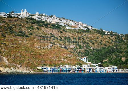 Klima and Plaka villages with whitewhashed traditional houses and orthodox church and windmills on Milos island, Greece