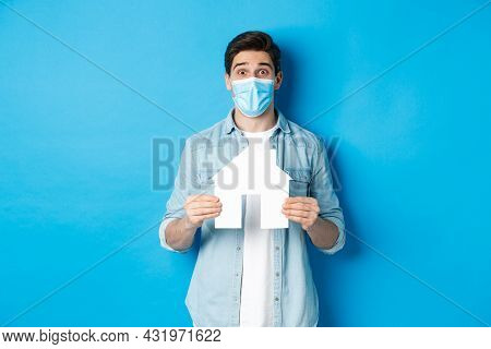 Concept Of Coronavirus, Quarantine And Social Distancing. Young Man Searching Apartment, Showing Hou