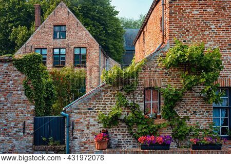 Old housesof Begijnhof Beguinage with flowers in Bruges town. Brugge, Belgium