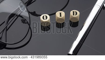 Oid Concept, Words On Wooden Blocks On Black Background With Pen And Glasses.