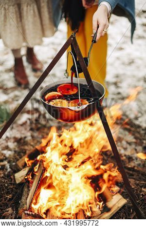 From Above Traditional Mulled Wine With Slices Of Orange Preparing In Pot Over Burning Logs In Winte