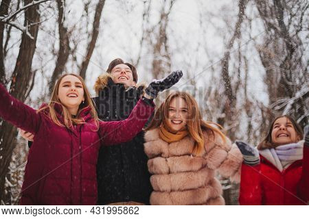 Group Of Four Joyful Best Friends Enjoying Cold Weather And First Snow Standing Outdoor Over Snow Co