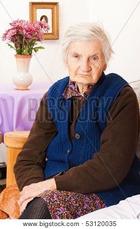 Elderly Lonely Woman Sits On The Bed