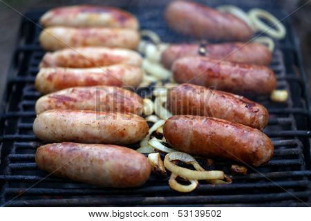 A lot of bratwurst sausages on grill.