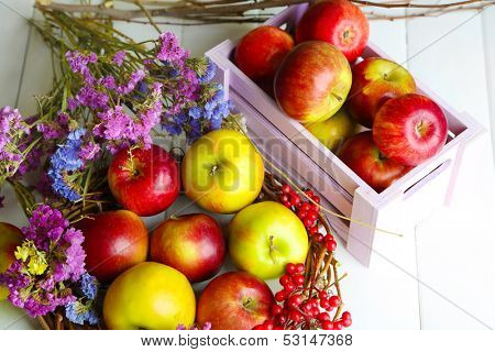 Juicy apples in box on white wooden table
