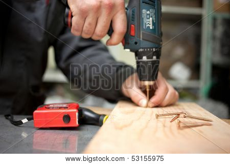 Man with screwdriver. Focused on screw in front. Clouseup concept